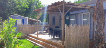 pergola en bois posé sur une terrasse en pin par l'entreprise occia dans un camping a marseillan plage