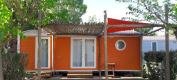 pergola en bois et toile de qualité devant un bungalow dans un camping à vias conception et pose par l'entreprise occia conception bois
