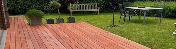 Terrasse en lames de Padouk rouge dans jardin résidentiel avec mobilier extérieur