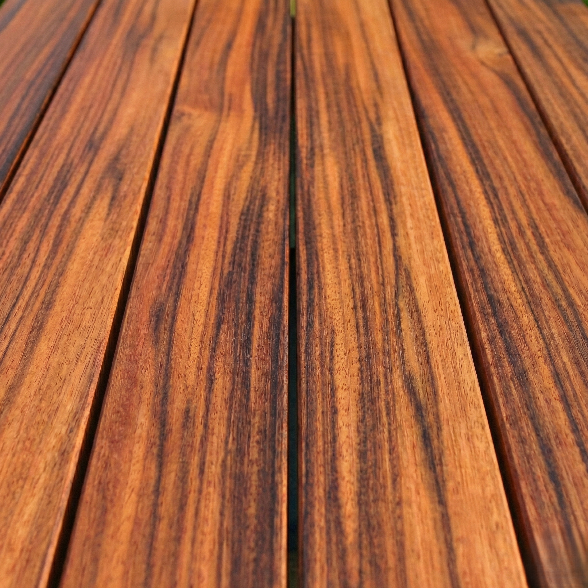 Lames de terrasse en bois Muiracatiara Tigerwood, veinage noir tigré sur fond brun orangé, bois exotique classe 4
