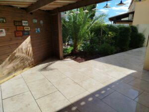 Terrasse moderne en grès céramique avec carreaux rectangulaires posés en décalé 2/3, aménagement extérieur par Occia à Florensac dans l'Hérault (34)